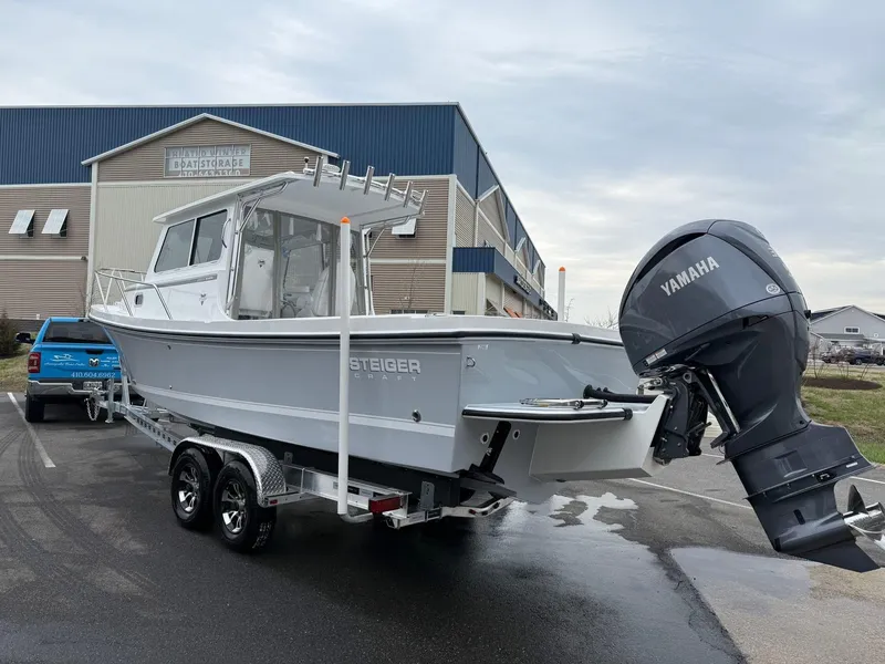 Slide: The Image of 2025 Steiger Craft 255 Miami boat with Yamaha engine on trailer, parked outdoors. - 2