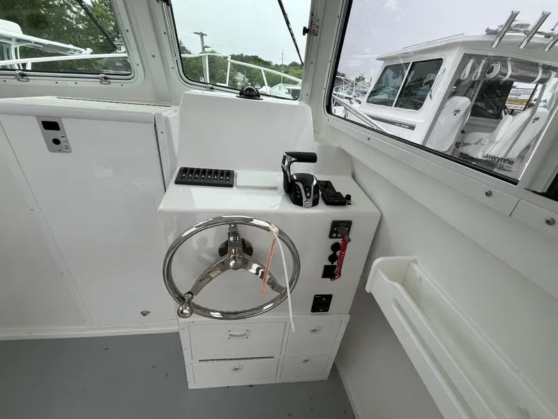 Slide: The Image of 2025 Steiger Craft 255 Miami helm with steering wheel and controls. - 6