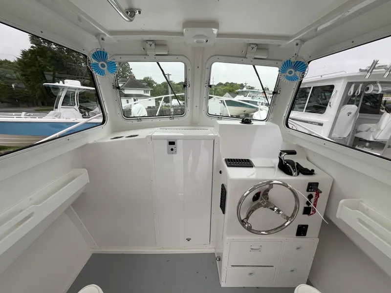 Slide: The Image of 2025 Steiger Craft 255 Miami boat interior with steering wheel and windows. - 7