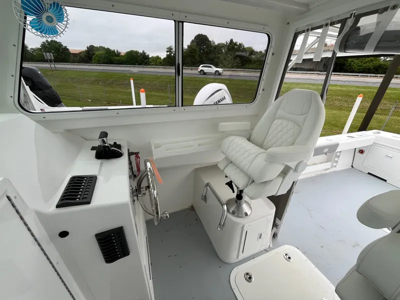 Slide: The Image of 2025 Steiger Craft 255 Miami boat interior with captain's chair and control panel. - 8