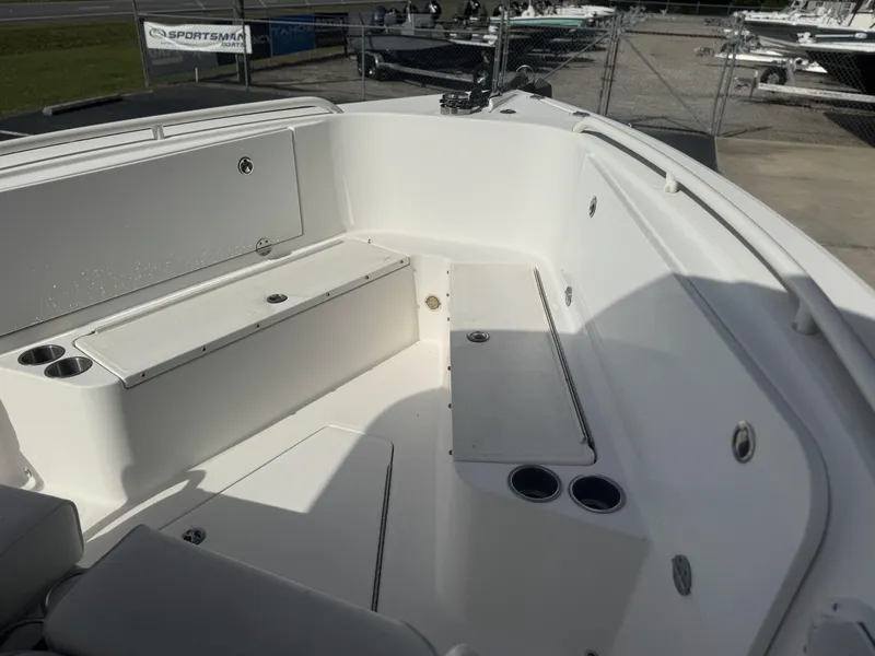 Slide: The Image of 2007 Everglades 260CC boat interior with seating and cup holders, docked outdoors. - 11