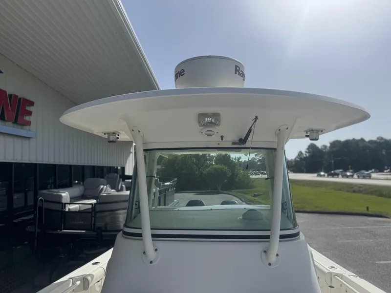 Slide: The Image of 2007 Everglades 260CC boat with radar, parked near a building on a sunny day. - 8