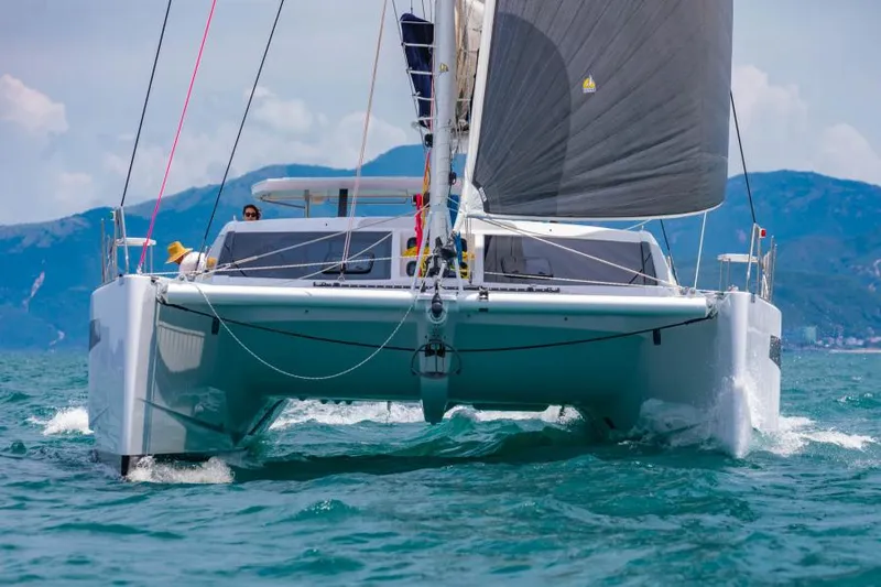 Slide: The Image of 2025 Seawind 1600 Passagemaker catamaran sailing on open water with mountains in background. - 10