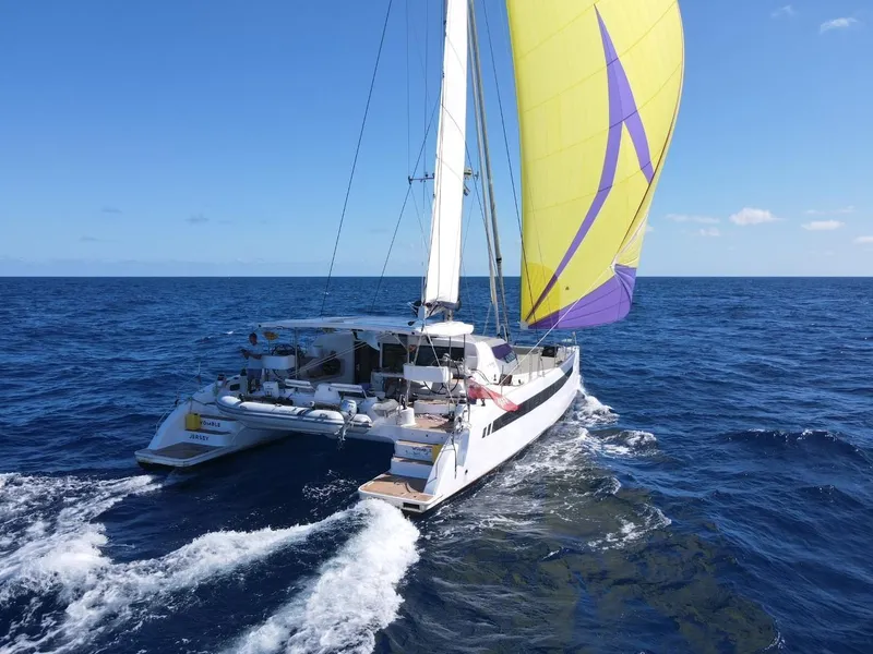 Slide: The Image of Seawind 1600 Passagemaker 2025 catamaran sailing on open ocean with vibrant yellow sail. - 12