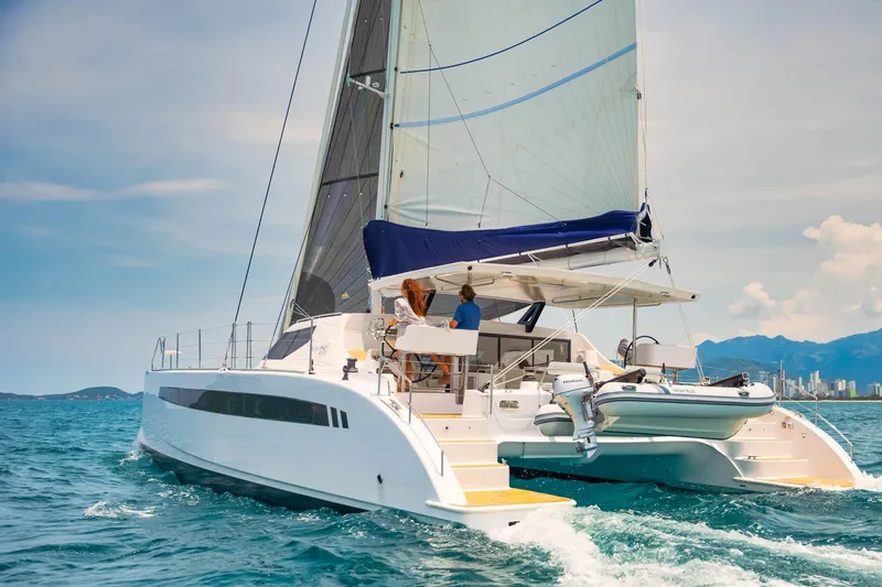 Slide: The Image of 2025 Seawind 1600 Passagemaker sailing on open water, clear sky, and distant mountains. - 16