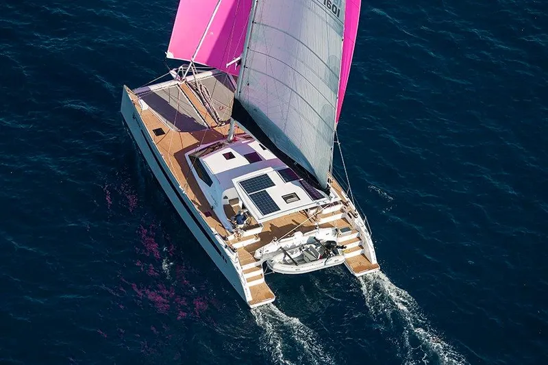 Slide: The Image of 2025 Seawind 1600 Passagemaker sailing catamaran with pink sails on open water. - 18