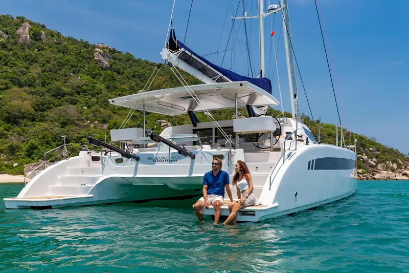 Slide: The Image of Couple relaxing on Seawind 1600 Passagemaker catamaran, 2025 model, in tropical waters. - 27