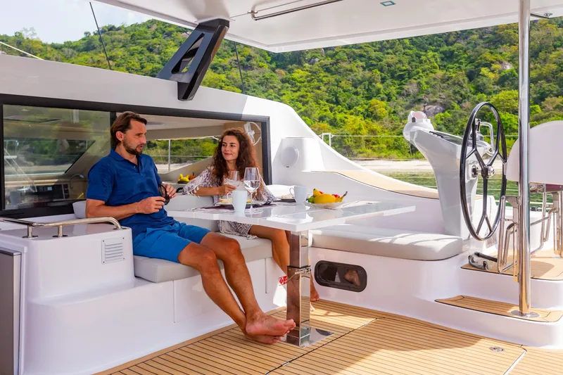 Slide: The Image of Couple relaxing on 2025 Seawind 1600 Passagemaker yacht, enjoying a meal with scenic view. - 31