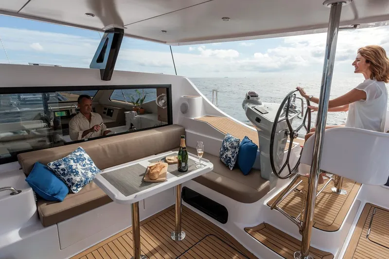 Slide: The Image of 2025 Seawind 1600 Passagemaker yacht interior with seating, table, and steering wheel. - 33