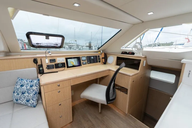 Slide: The Image of Interior of 2025 Seawind 1600 Passagemaker yacht with navigation station and seating area. - 34