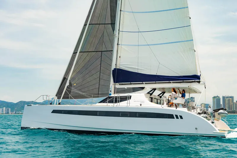 Slide: The Image of 2025 Seawind 1600 Passagemaker sailing on blue ocean near city skyline. - 4
