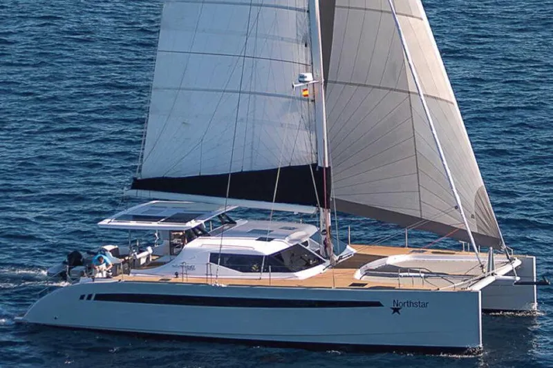 Slide: The Image of 2025 Seawind 1600 Passagemaker catamaran sailing on open sea with full sails. - 7