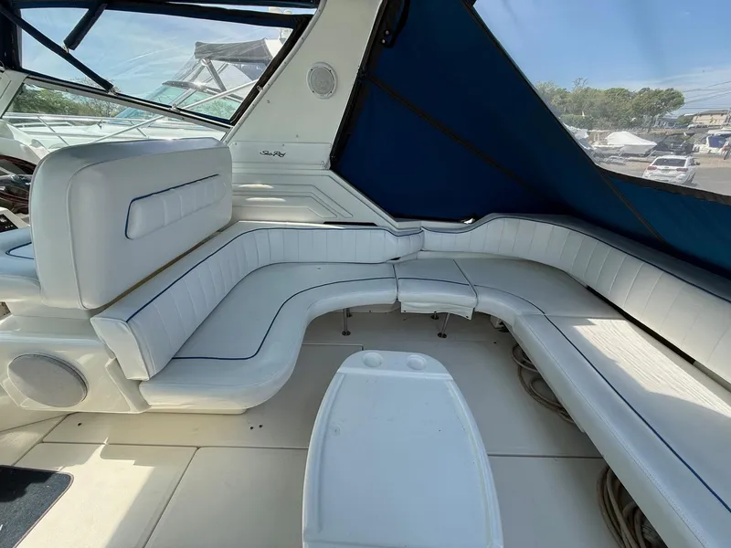 Slide: The Image of 1995 Sea Ray 400 Express Cruiser interior with white seating and blue canopy. - 14
