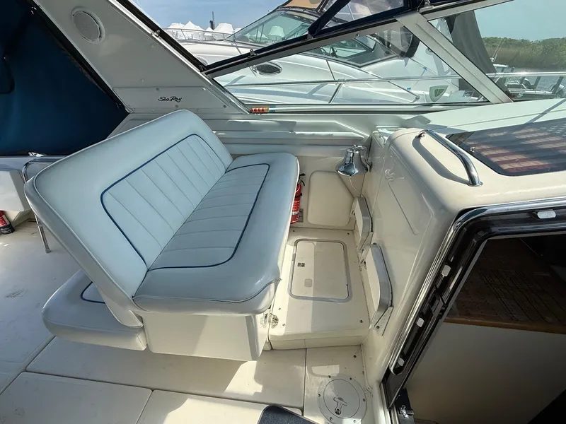 Slide: The Image of 1995 Sea Ray 400 Express Cruiser interior with white seating and helm area. - 16