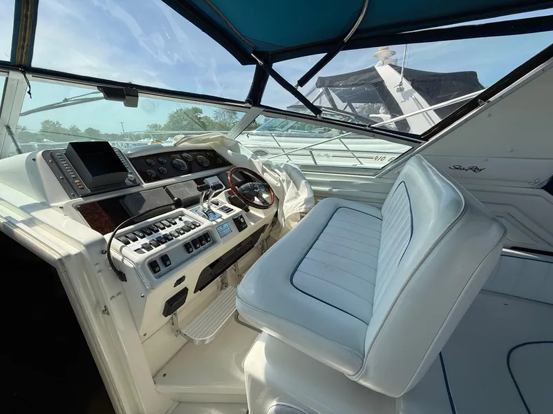 Slide: The Image of 1995 Sea Ray 400 Express Cruiser helm with white seating and control panel. - 18