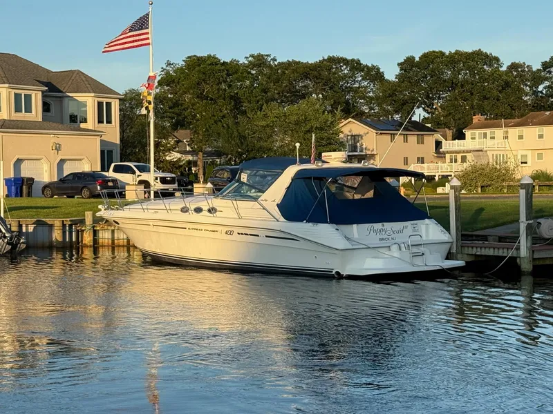 Slide: The Image of 1995 Sea Ray 400 Express Cruiser docked by a waterfront home. - 2