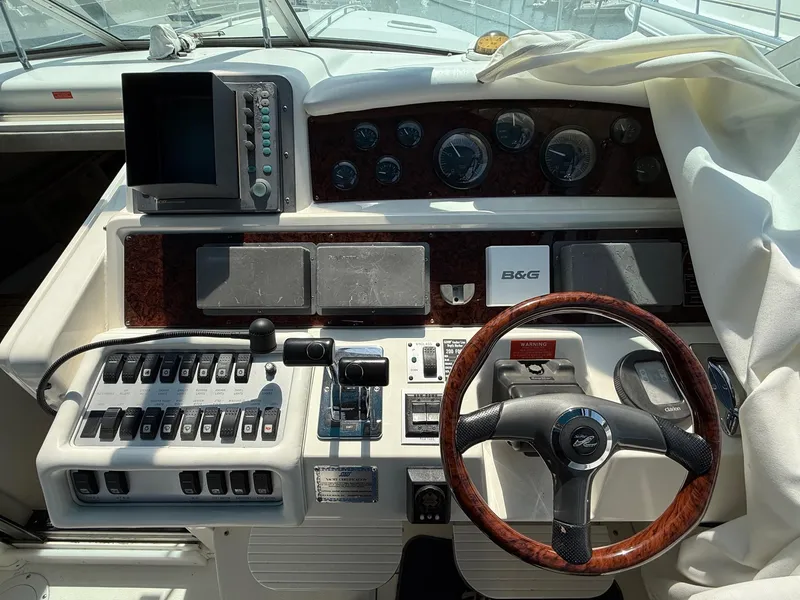 Slide: The Image of 1995 Sea Ray 400 Express Cruiser helm with steering wheel and navigation controls. - 20