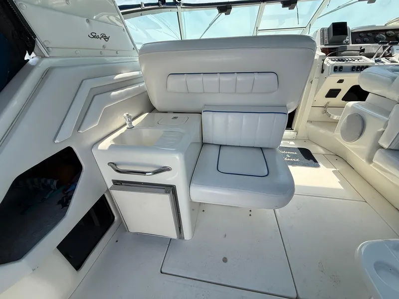 Slide: The Image of 1995 Sea Ray 400 Express Cruiser interior with white seating and compact kitchenette. - 21