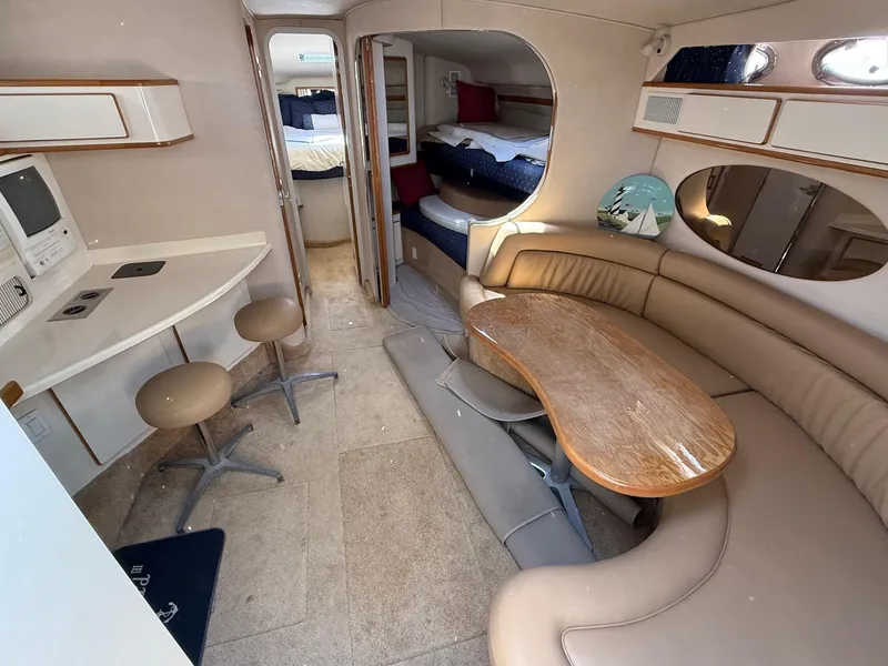 Slide: The Image of 1995 Sea Ray 400 Express Cruiser interior with seating, table, and sleeping area. - 22