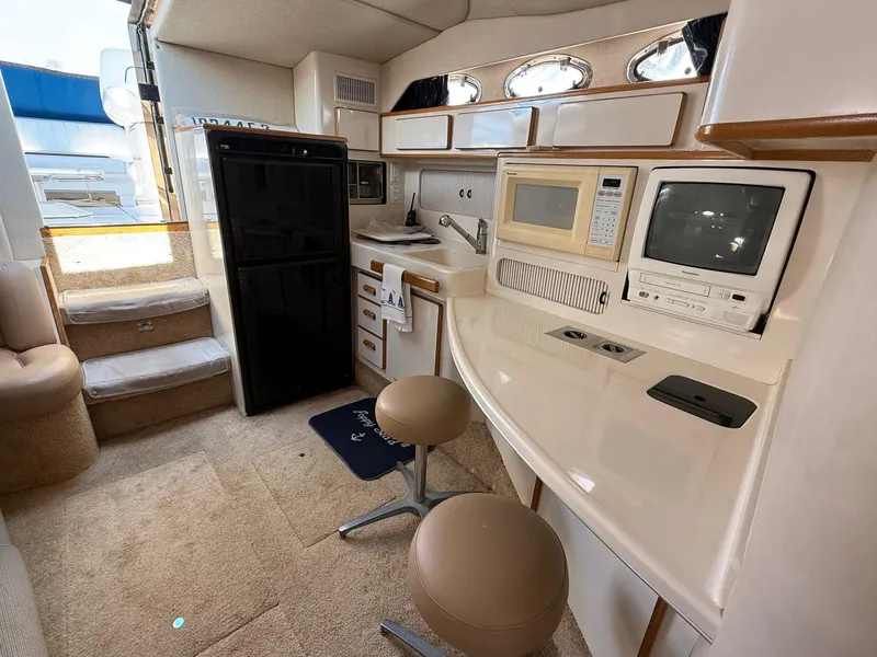 Slide: The Image of Interior of 1995 Sea Ray 400 Express Cruiser with kitchen and seating area. - 24