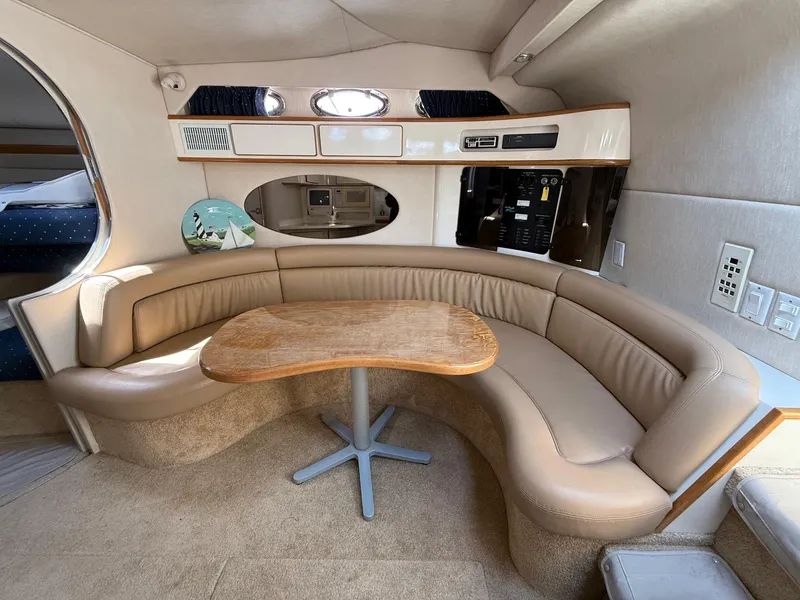 Slide: The Image of 1995 Sea Ray 400 Express Cruiser interior with curved leather seating and wooden table. - 27