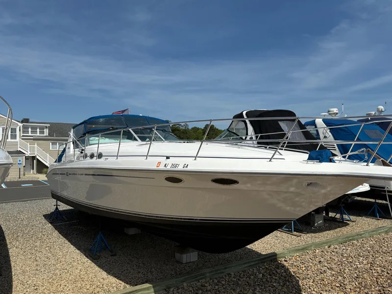 Slide: The Image of 1995 Sea Ray 400 Express Cruiser on display, parked on gravel with clear blue sky. - 4