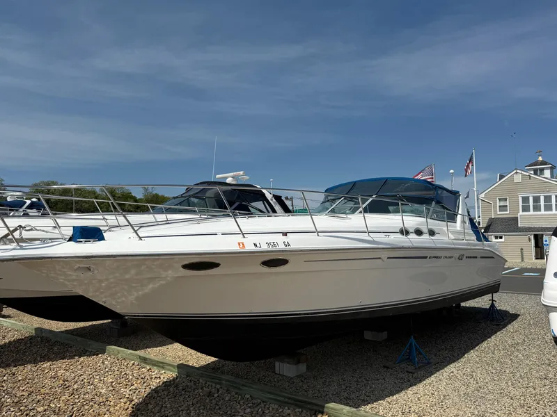 Slide: The Image of 1995 Sea Ray 400 Express Cruiser docked on land under clear blue sky. - 6