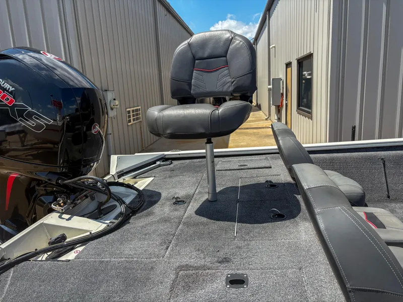 Slide: The Image of 2023 Tracker Pro Team 195 TXW Tournament Edition boat with seating and motor, docked outdoors. - 6