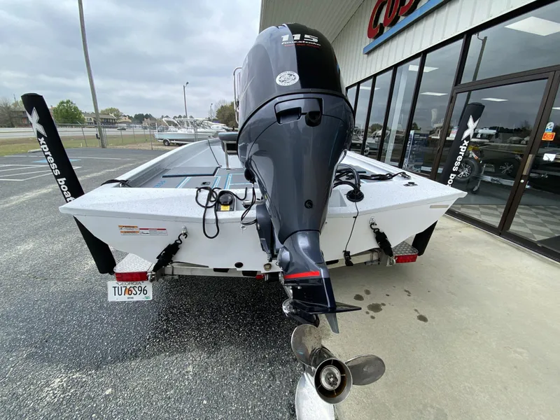 Slide: The Image of 2021 Xpress H190B boat with outboard motor, parked outside a dealership. - 5
