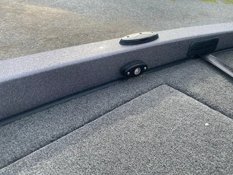 Slide: The Image of 2015 Ranger Z118 Comanche boat interior with textured gray surface and mounted hardware. - 13