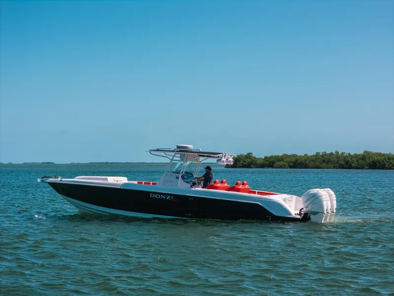 Slide: The Image of 2007 Donzi 38 ZF Cuddy boat cruising on calm blue waters. - 0