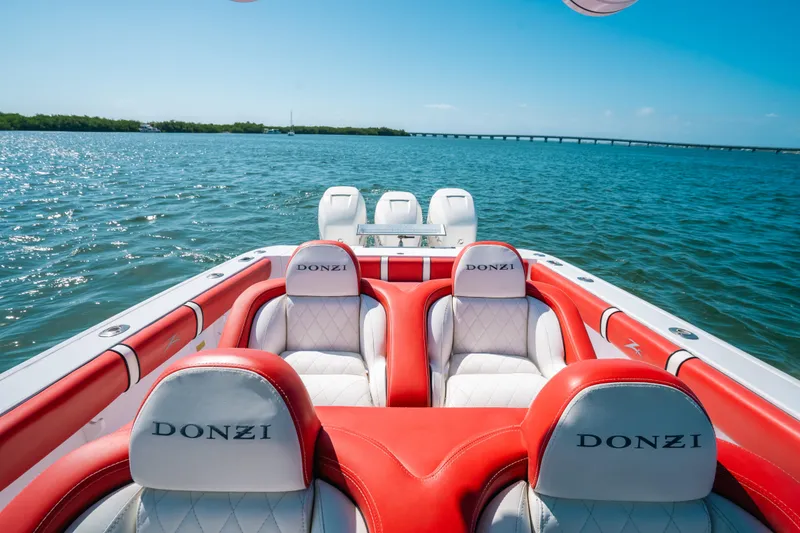 Slide: The Image of 2007 Donzi 38 ZF Cuddy boat with red and white seating on open water. - 12
