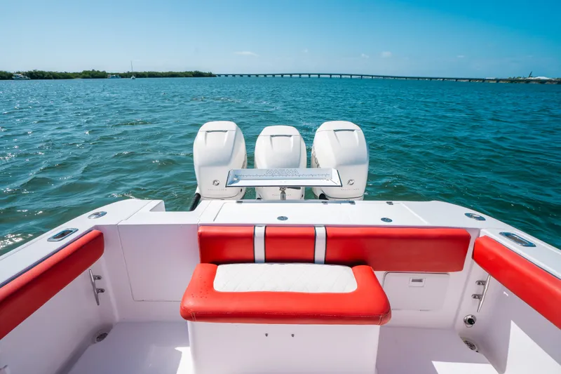 Slide: The Image of 2007 Donzi 38 ZF Cuddy boat with red seating, triple engines, on open water. - 15
