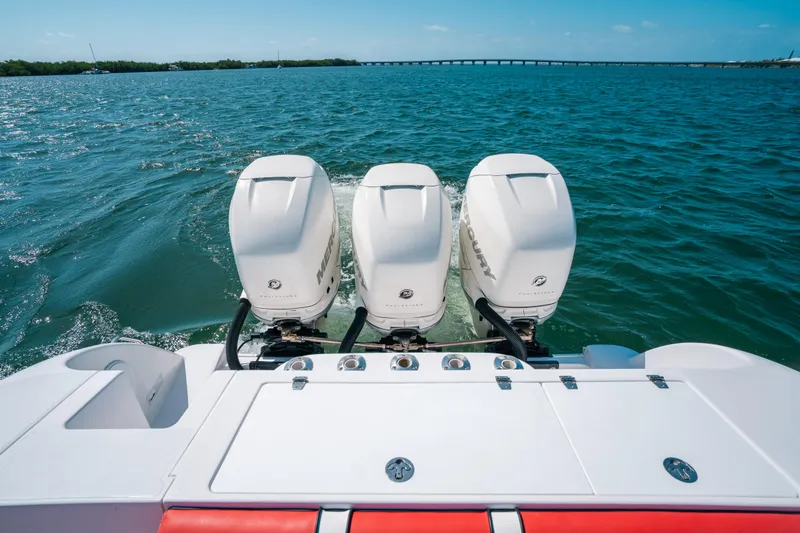 Slide: The Image of 2007 Donzi 38 ZF Cuddy with triple outboard engines on open water. - 2