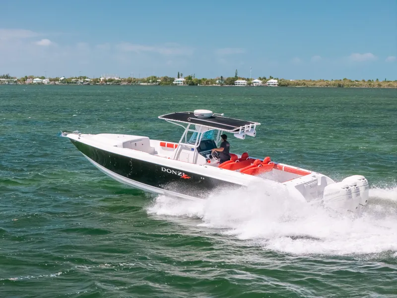 Slide: The Image of 2007 Donzi 38 ZF Cuddy speeding on open water under clear skies. - 30