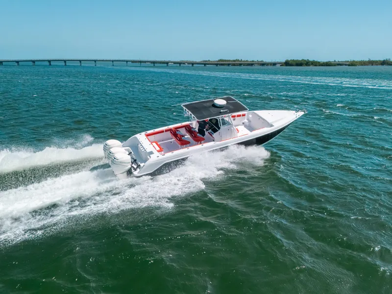 Slide: The Image of 2007 Donzi 38 ZF Cuddy speeding on open water, bridge in background. - 33