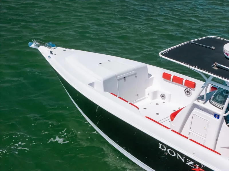 Slide: The Image of 2007 Donzi 38 ZF Cuddy boat on green water, showcasing sleek design and spacious deck. - 5