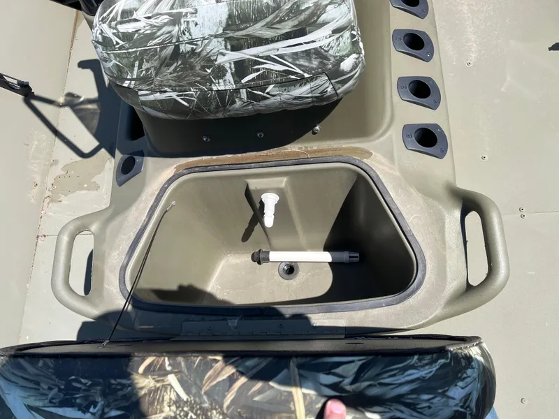 Slide: The Image of 2024 Tracker Grizzly 2072 CC boat interior with storage compartment and camo seat. - 6