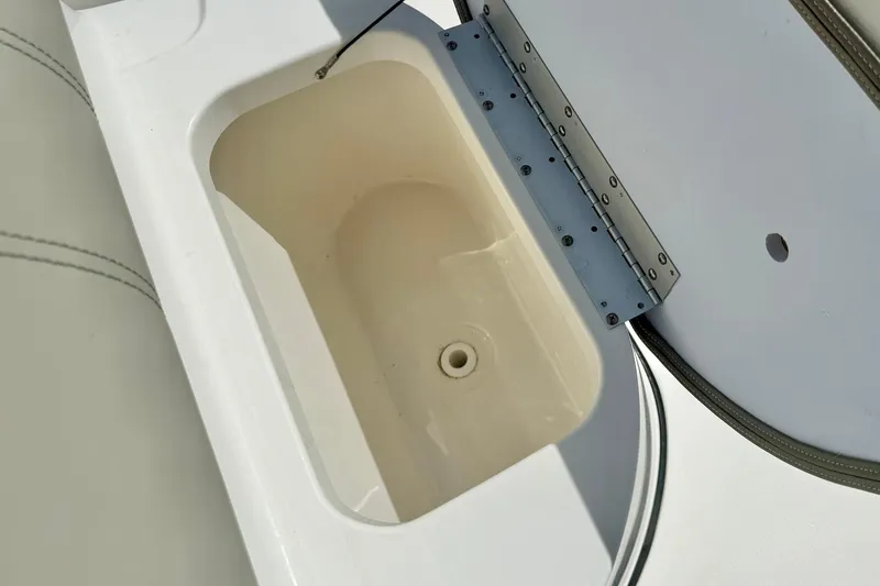 Slide: The Image of 2023 Key West 189 FS boat storage compartment, open lid, white interior. - 16