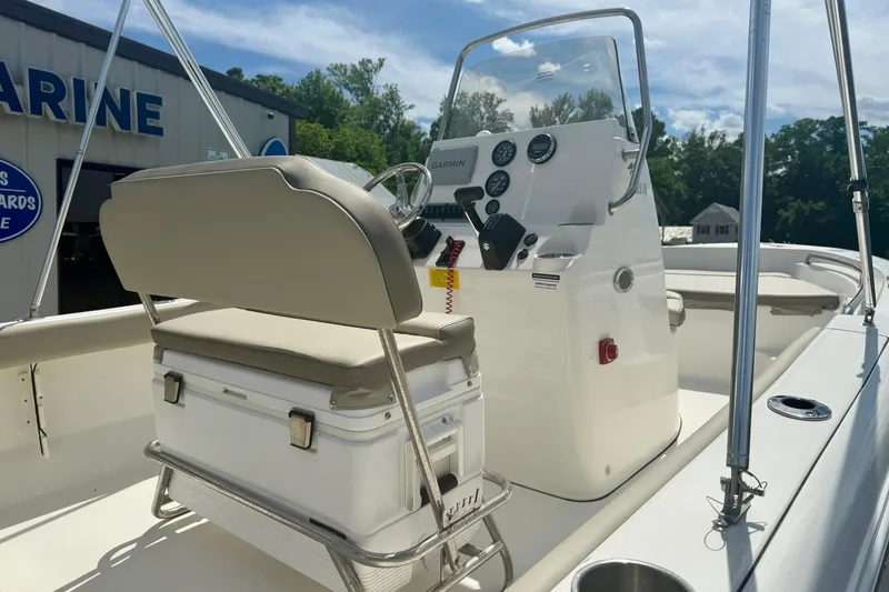 Slide: The Image of 2023 Key West 189 FS boat interior with console and seating, parked outdoors. - 17