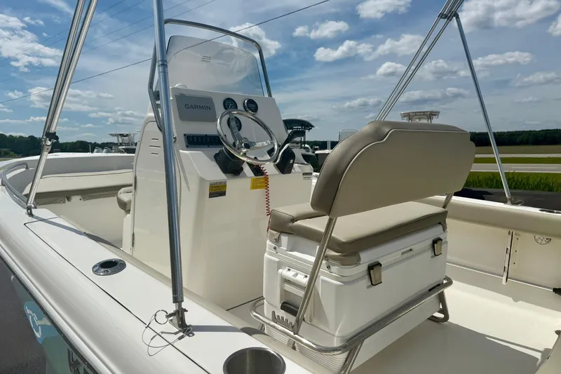 Slide: The Image of 2023 Key West 189 FS boat interior with steering console and seating under a clear sky. - 18