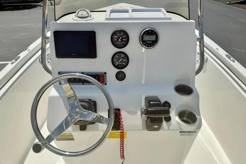 Slide: The Image of 2023 Key West 189 FS boat console with steering wheel, gauges, and cup holders. - 2