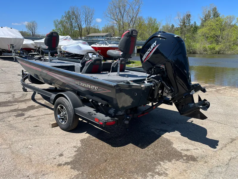 Slide: The Image of 2024 Ranger RT188C fishing boat with Mercury engine, parked near a lake. - 2