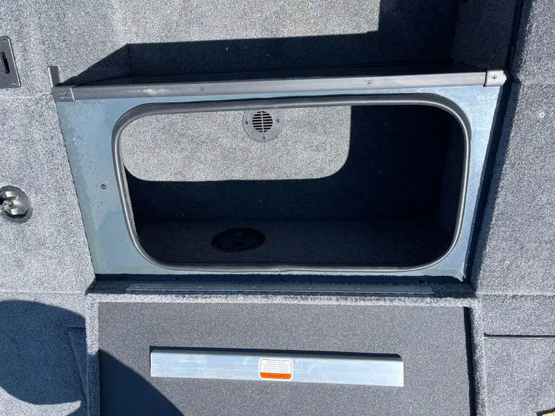 Slide: The Image of 2024 Ranger RT188C boat storage compartment with gray interior and drainage feature. - 9