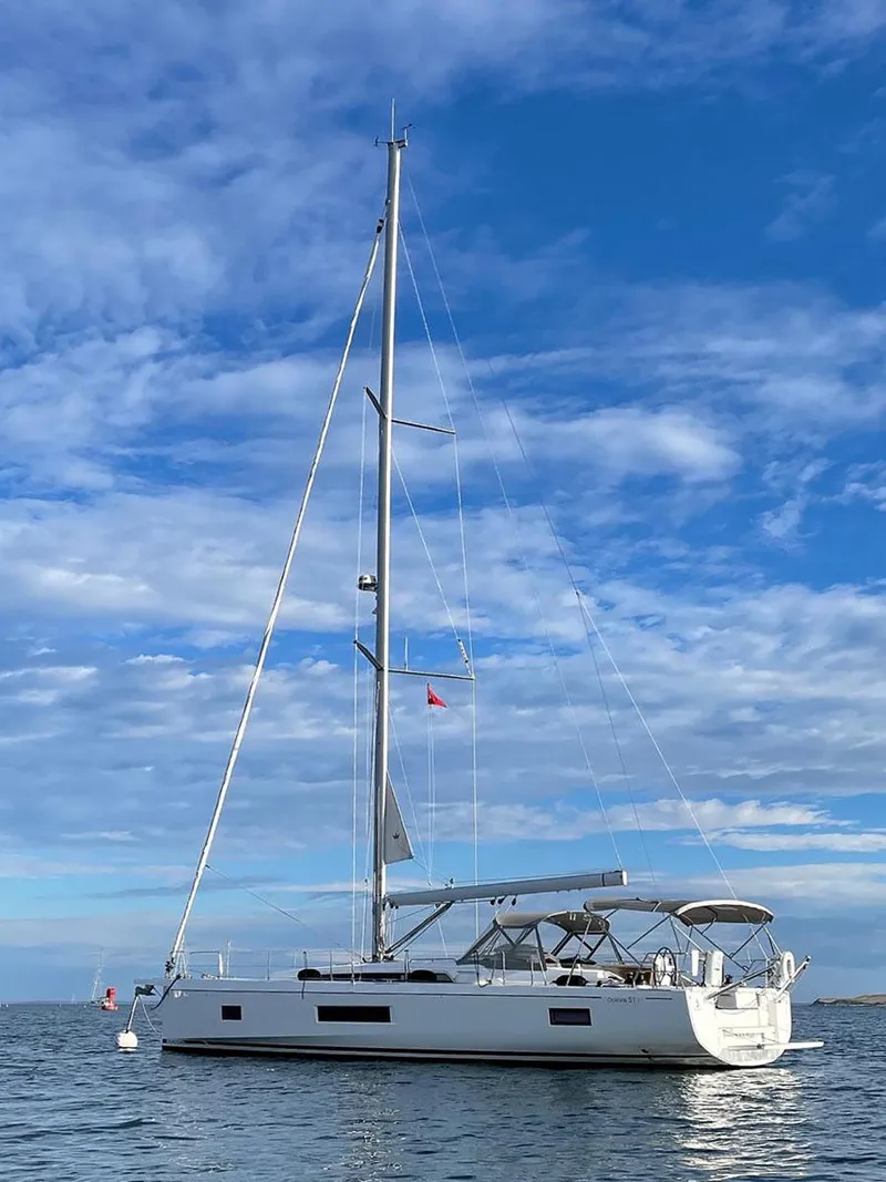 Slide: The Image of 2020 Beneteau Oceanis 51.1 sailboat on calm water under a blue sky. - 2