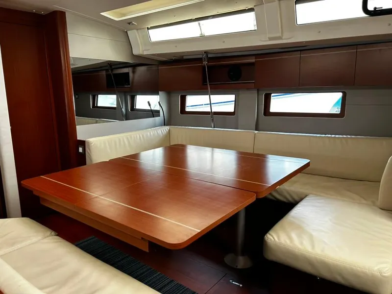 Slide: The Image of Interior of 2020 Beneteau Oceanis 51.1 yacht with wooden table and white seating. - 25