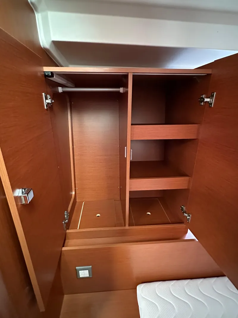 Slide: The Image of Wooden closet interior on 2020 Beneteau Oceanis 51.1 yacht, featuring shelves and hanging space. - 39