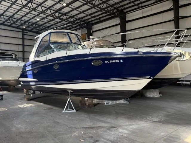 Slide: The Image of 2013 Monterey 340 Sport Yacht in storage, blue and white exterior, indoor facility. - 0