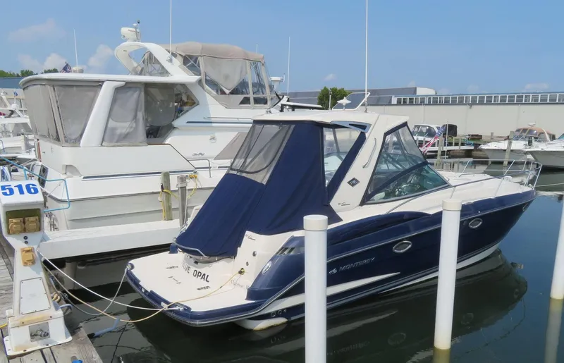 Slide: The Image of 2013 Monterey 340 Sport Yacht docked at marina, featuring sleek design and blue cover. - 1