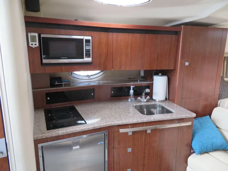 Slide: The Image of 2013 Monterey 340 Sport Yacht kitchen with microwave, sink, and stove. - 11